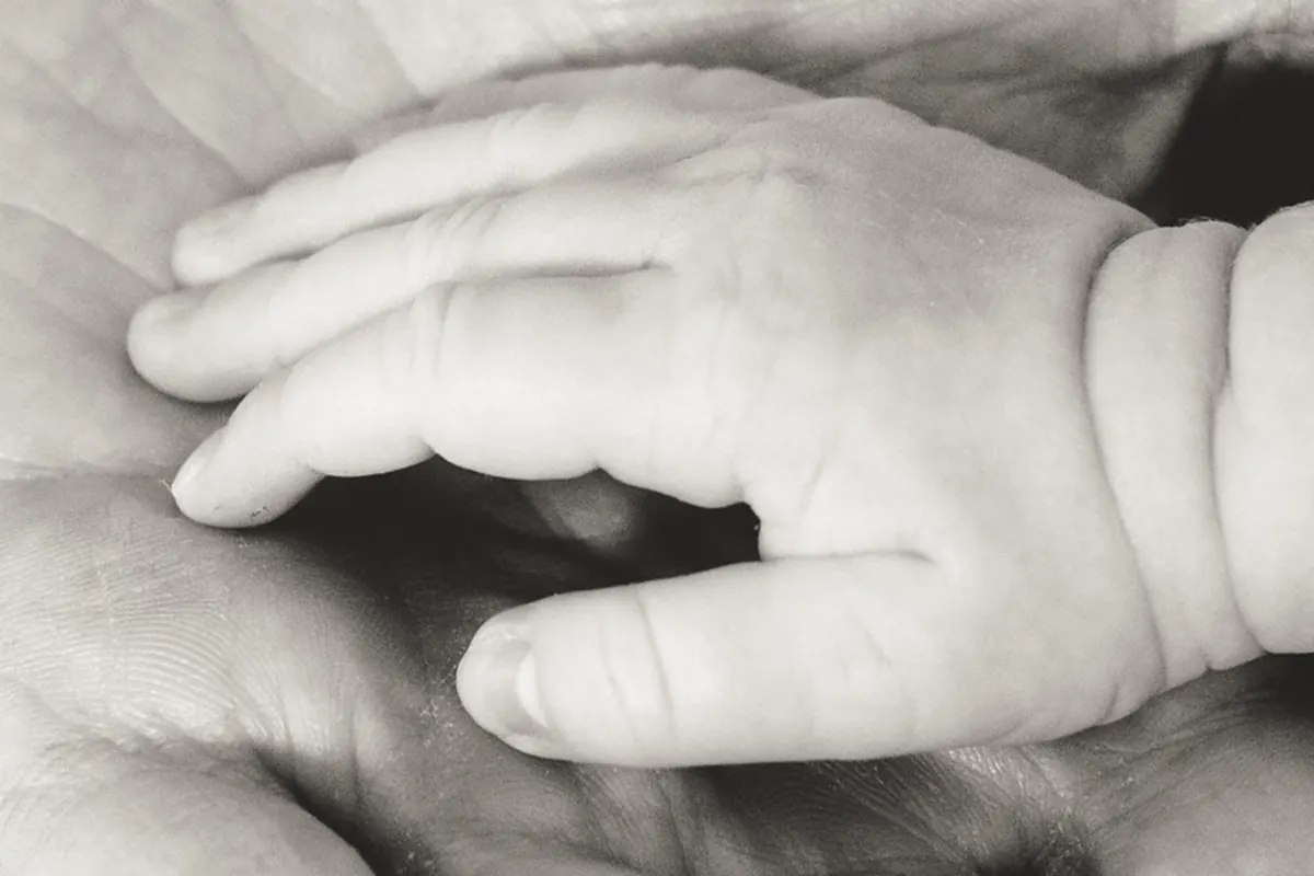 Babyhandje in de hand van een volwassene